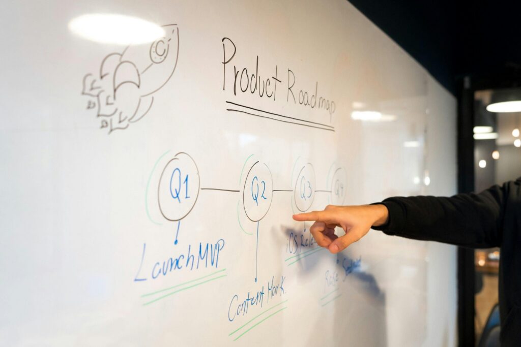 Image of a hand showing some text on a white board.